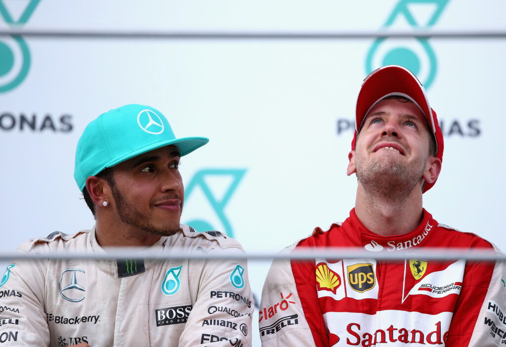 Lewis Hamilton and Sebastian Vettel sitting next to each other on the podium of the Malaysian Grand Prix